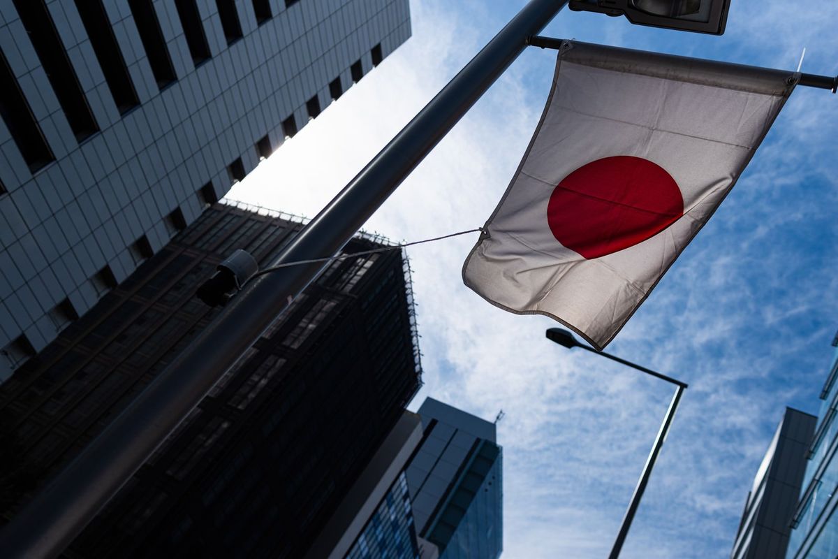 青空の下で力強く翻る日本の国旗
